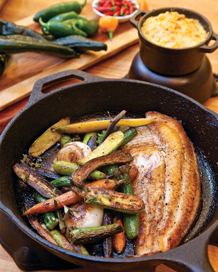 Fish and vegetables served in a cast-iron skillet