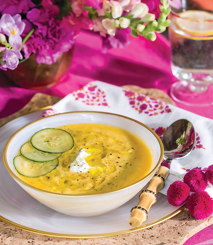 Yellow Tomato Gazpacho garnished with cucumber in a white bowl