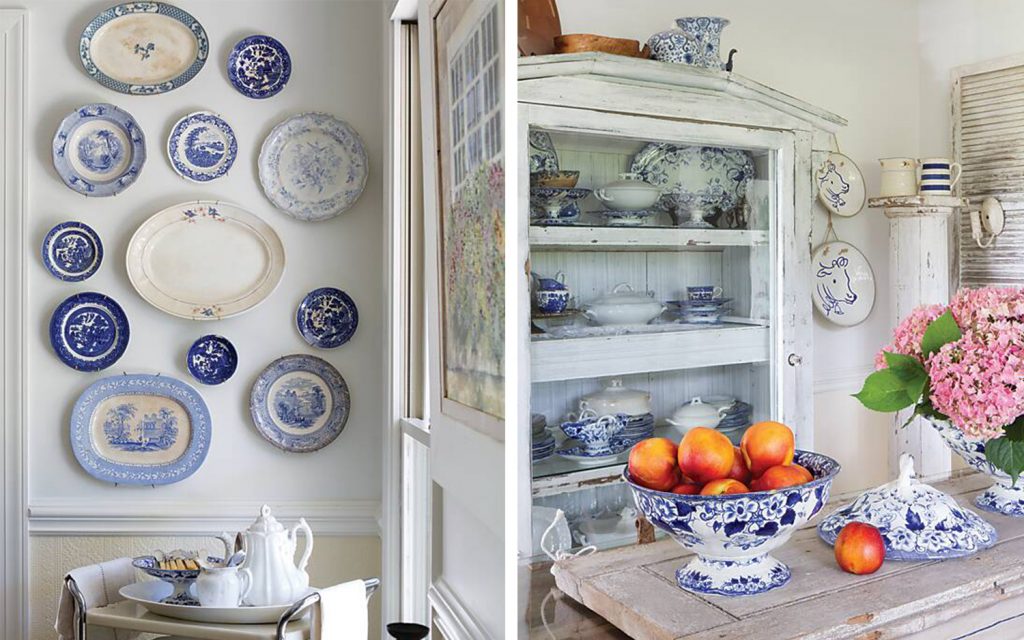A wall decorated with mismatched blue-and-white plates and a kitchen decorated with blue-and-white vessels holding peaches and pink flowers