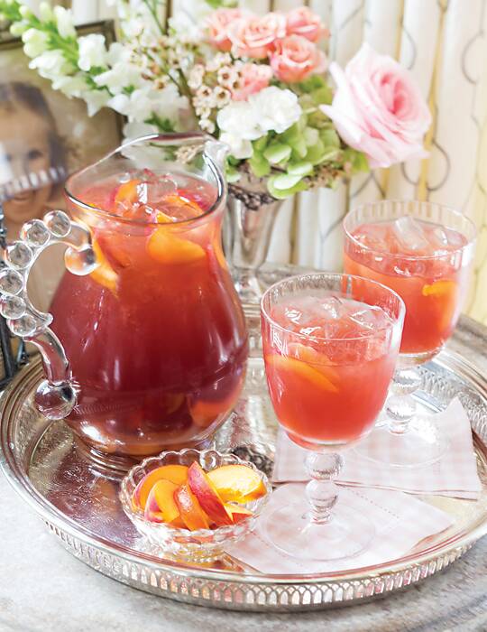 A clear pitcher and 2 glasses of Peach-Infused Sweet Tea