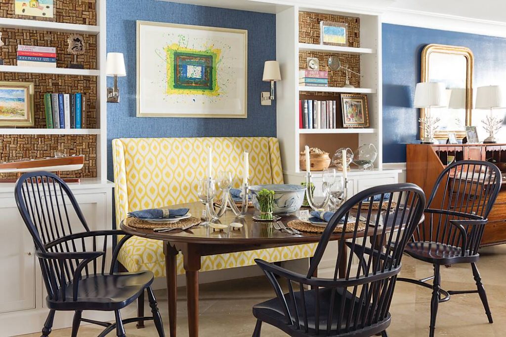 Dining area with blue walls and yellow-and-white banquette