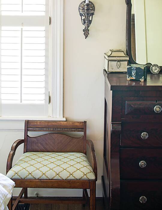 Southern hospitality in bedroom featuring a small antique bench