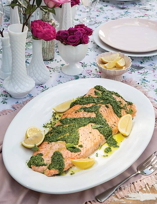 Roasted Salmon with Pesto and lemon wedges on a white platter