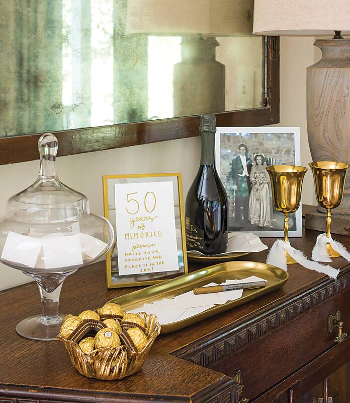 Gold goblets, a black-and-white photo, and a gold tray on a sideboard