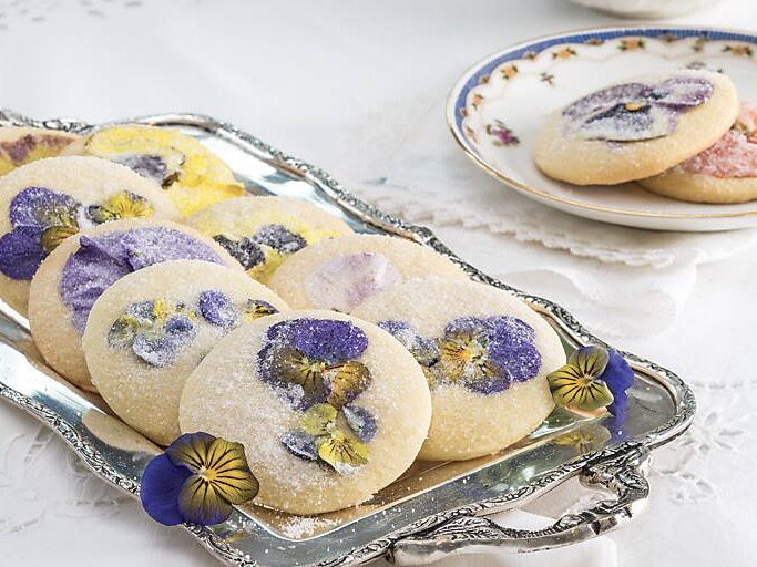 A silver tray of flower-adorned sugar cookies