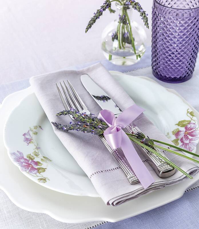 White china topped with lilac linen and fresh lavender