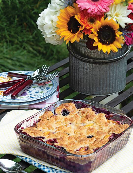Peach and blueberry cobbler in a clear glass dish