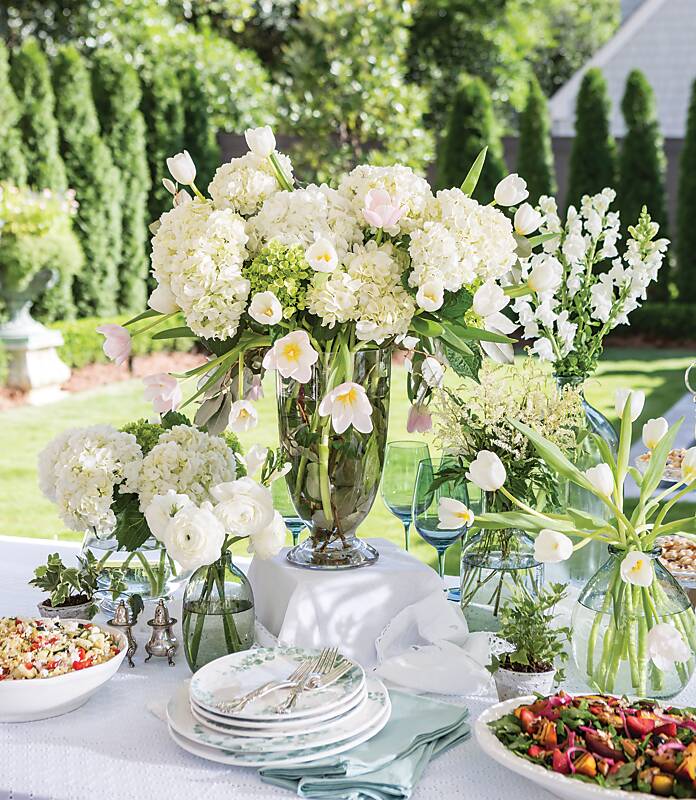 Tablescape of white and pale blue in a lush garden