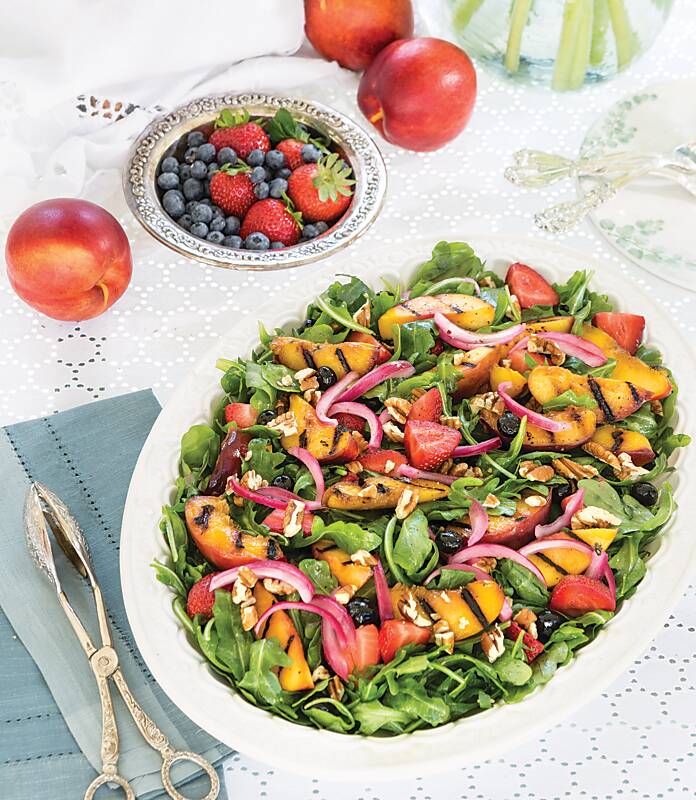 Arugula Salad with Nectarines and red onion on a white dish