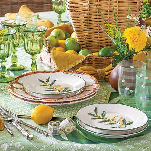 Tabletop adorned with green and yellow tableware and fresh citrus