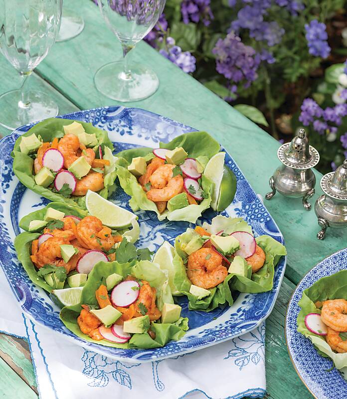 Shrimp lettuce wraps with sliced radish on a blue-and-white platter
