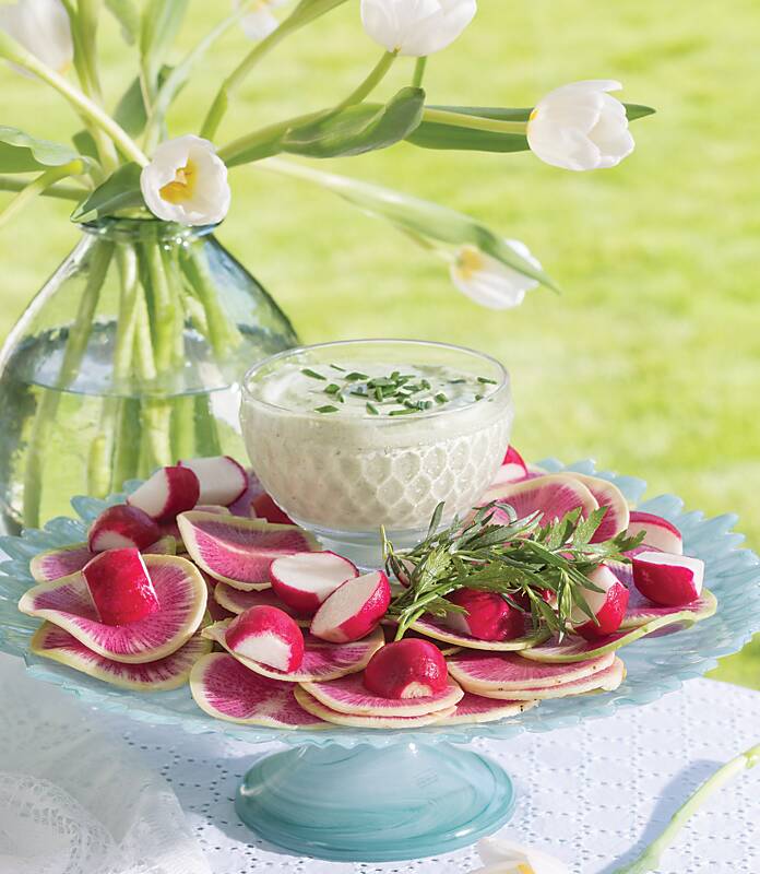 Watermelon radishes and radishes on a blue cake stand
