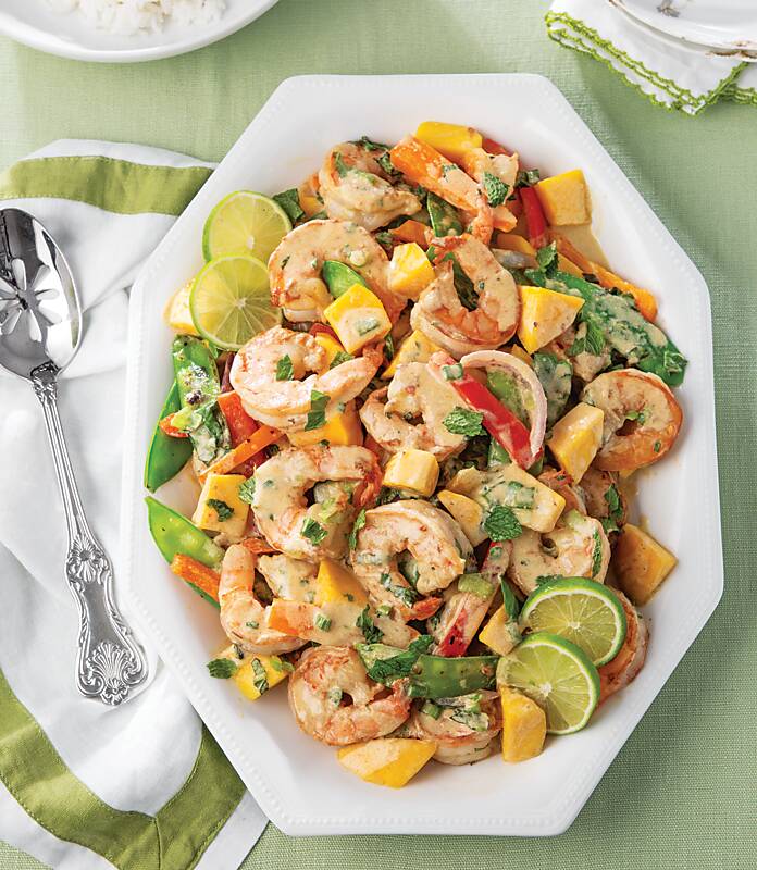 Shrimp, mango, snap peas, and bell pepper stir-fry in a white serving dish