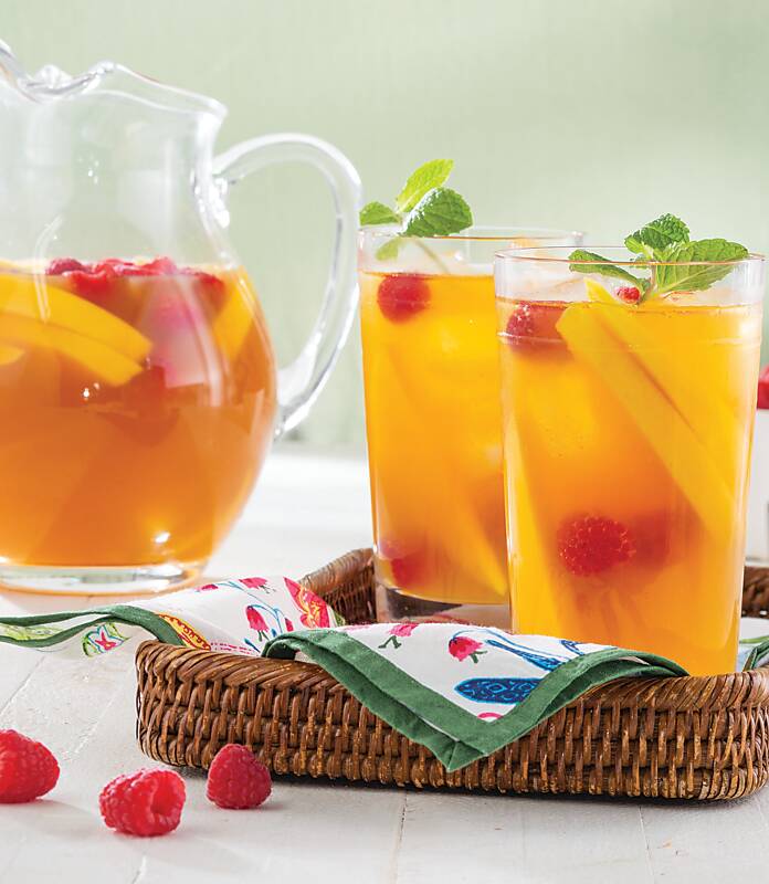 Mango-Raspberry Iced Tea in a pitcher and two tall glasses