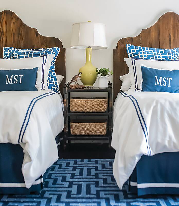 Twin beds decorated with blue and white linens