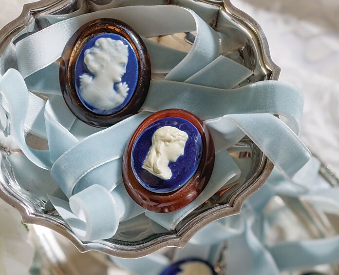 Beautiful cameos on blue backgrounds atop pale blue ribbon