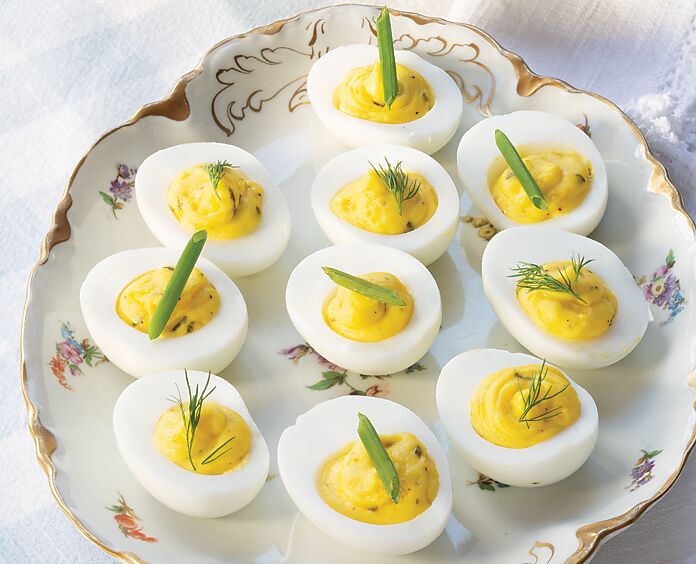 Herbed Deviled Eggs on a white floral dish