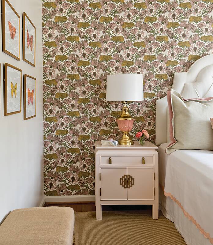 A bedroom featuring an accent wall of pink floral wallpaper