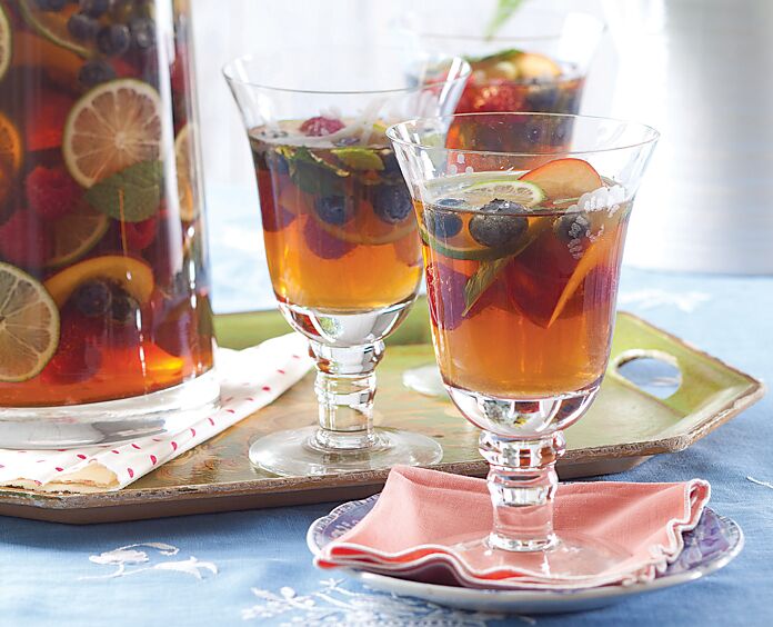Sweet Tea Sangria in a pitcher and three stemmed glasses